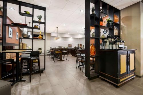 a restaurant with a bar with tables and chairs at Revel Hotel Minot - SureStay Collection by Best Western in Minot