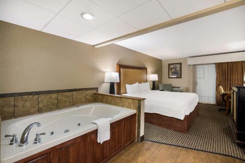 a hotel room with a bed and a bath tub at Revel Hotel Minot - SureStay Collection by Best Western in Minot