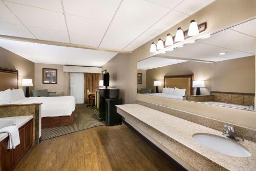 a hotel room with a bed and a bathroom at Revel Hotel Minot - SureStay Collection by Best Western in Minot
