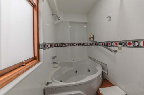 a white bath tub in a bathroom with a window at Quechua Hotel Cusco in Cusco