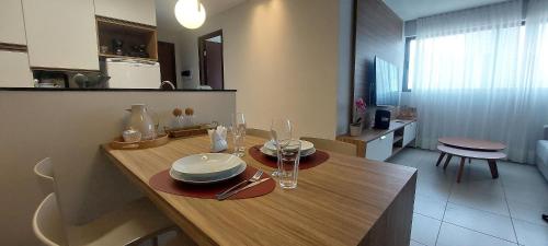a kitchen with a table with plates and glasses on it at Beach Class Convention - Flats em Boa Viagem por Yolo in Recife