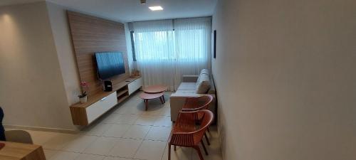 a living room with a couch and a tv at Beach Class Convention - Flats em Boa Viagem por Yolo in Recife