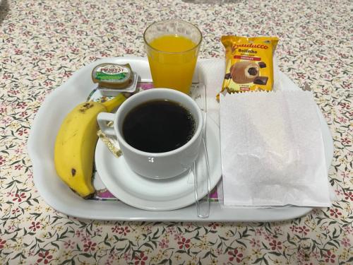 カンピーナスにあるHotel Taquaralのコーヒーとバナナが入った朝食プレート