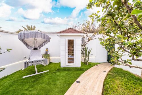 un jardín con silla y césped en Privé Paradise, en Maspalomas