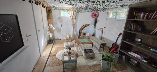 LongevesにあるMaison Damourのテーブルと椅子とギターのあるリビングルーム