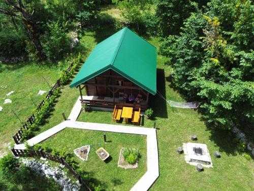 a small house with a green roof in a yard at Cabin House Dubovik in Cetinje