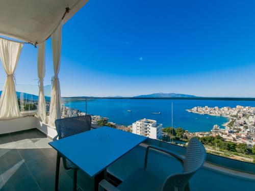 a blue table and chairs on a balcony with a view of the ocean at Sunset Shoreline Saranda - Sea View - Free Private Parking - Pool in Sarandë