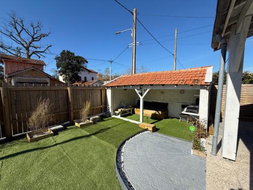 une cour avec une clôture et une cour avec de l'herbe verte dans l'établissement Maison seconde ligne Lanton, à Taussat-les-Bains