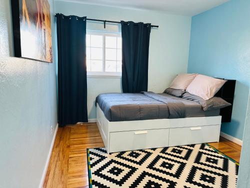 a small bedroom with a bed with a window at Hayward Home in Hayward