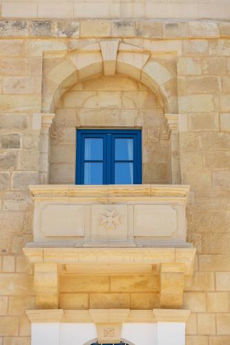 a window in a stone building with a blue window at Kirxa Rooms and Suites in Sliema