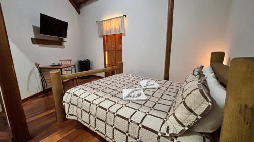 a bedroom with a bed with a cat sitting on it at Recanto da Natureza in Brotas