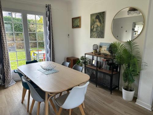 une salle à manger avec une table et un miroir dans l'établissement Le Temps de Vivre - Maison avec jardin proche Deauville, à Touques