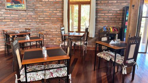 a restaurant with tables and chairs and a brick wall at Recanto da Natureza in Brotas