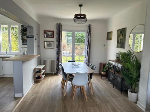une cuisine et une salle à manger avec une table et des chaises dans l'établissement Le Temps de Vivre - Maison avec jardin proche Deauville, à Touques