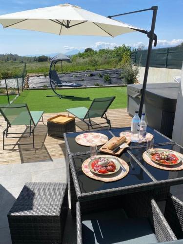 deux assiettes de nourriture sur une table avec un parapluie dans l'établissement Casa linsia, à Aléria