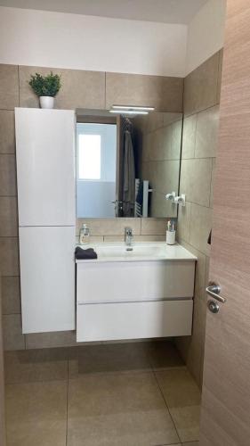 une salle de bain avec un lavabo blanc et un miroir dans l'établissement Casa linsia, à Aléria