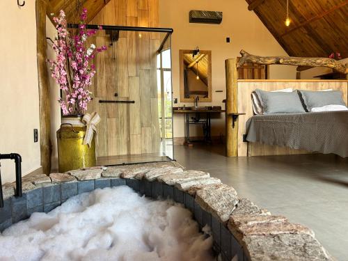 a bathtub filled with snow in a room with a bed at Recanto da Natureza in Brotas