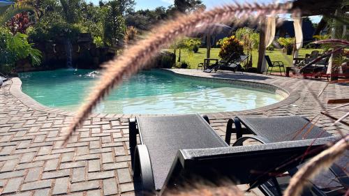 a swimming pool with a table and chairs next to it at Recanto da Natureza in Brotas