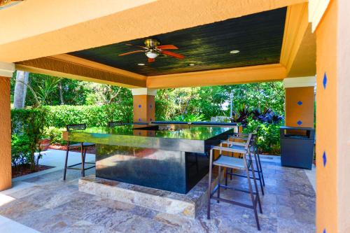 a patio with a bar with chairs and a ceiling at Modern Luxury Condo Near Beach & Aventura Mall in Aventura