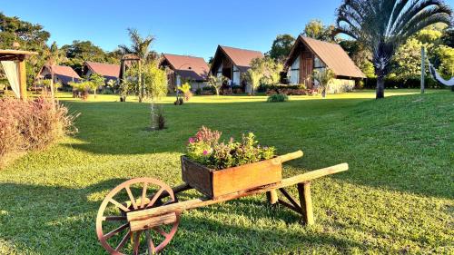 a wooden cart with a planter with flowers on it at Recanto da Natureza in Brotas