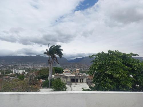 a view of a city with a palm tree and a building at La casa de wendy in Tuxtla Gutiérrez