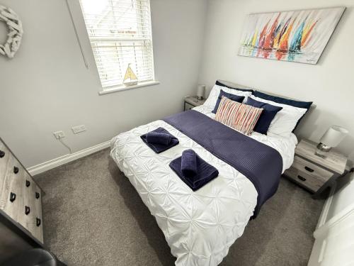 a bedroom with a large bed with blue pillows at The Puffin Pad in Filey
