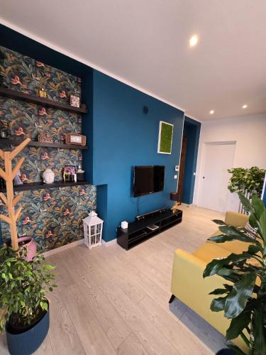 a living room with a blue wall and a tv at Eden in Chieri