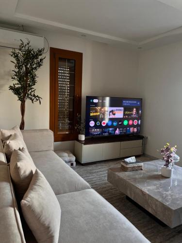 a living room with a couch and a flat screen tv at Private floor of a villa - 10 min to airport in Ariana