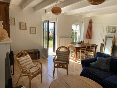 un salon avec un canapé, des chaises et une table dans l'établissement Le Gîte de Ker Ehden classé 3 étoiles, à Ploubazlanec