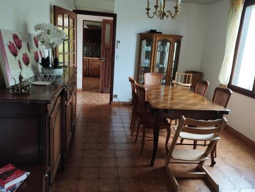 une salle à manger avec une table et des chaises en bois dans l'établissement Comme chez Mamies, à Saint-Dizier