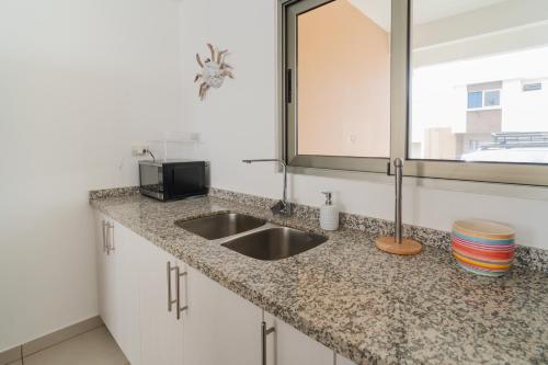 a kitchen counter with a sink and a mirror at Casa Surf in Zaragoza