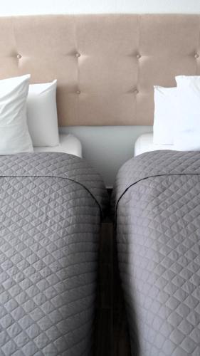 two beds sitting next to each other in a room at El Patio Hostal in Alicante