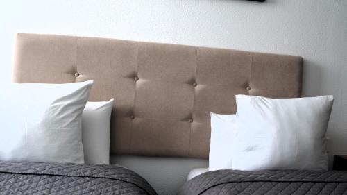 two beds with white pillows in a bedroom at El Patio Hostal in Alicante