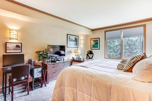 ein Schlafzimmer mit einem Bett, einem Schreibtisch und einem Fernseher in der Unterkunft Stay and Play Suncadia Resort Condo in Cle Elum in Cle Elum