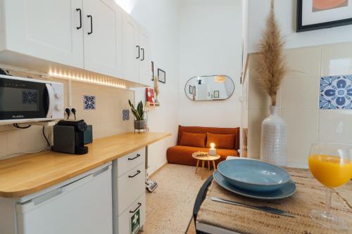 a kitchen with a table with a glass of orange juice at Cozy Old Town Apartment with Sunny Terrace in Vila do Bispo