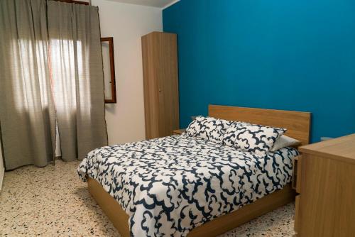 a bedroom with a bed and a blue wall at Casa Carrella in Salerno