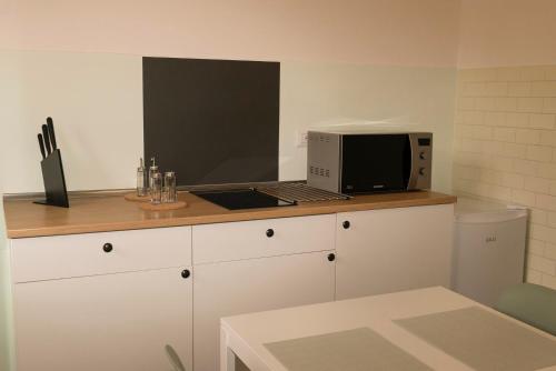 a kitchen with a microwave and a laptop on a counter at Casa Carrella in Salerno
