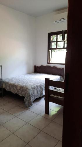 a bedroom with a bed and a window at Chácara Pedacinho do Céu in Socorro