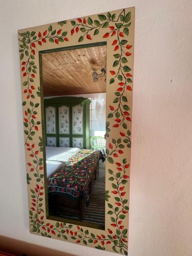 a mirror on a wall with a bed in a room at Ginkgo House in Kehidakustány