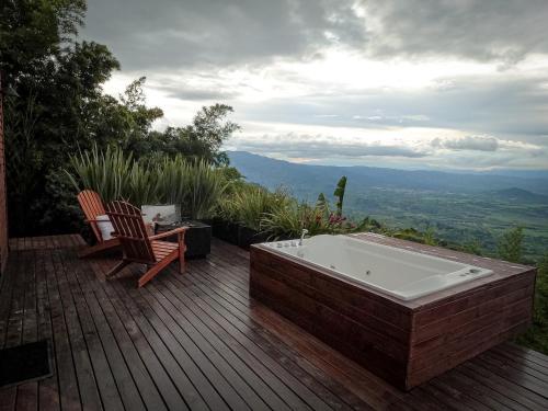 a bath tub on a deck with a table and chairs at La Cima Eco Hotel in Buenavista