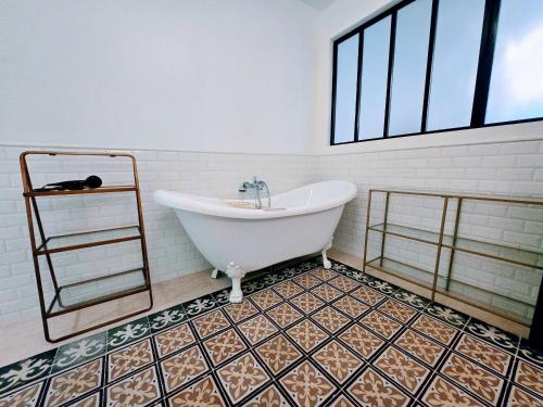 La salle de bains est pourvue d'une baignoire et de carrelage. dans l'établissement La Marine - Sejour a Auxerre, à Auxerre