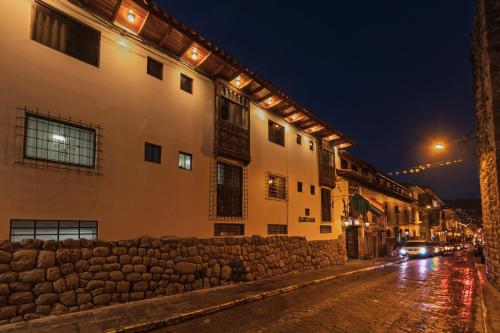 a city street at night with a building and cars at Quechua Hotel Cusco in Cusco