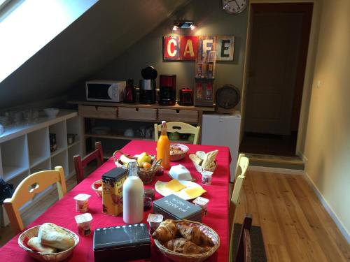 une table avec un tissu de table rouge et de la nourriture dans l'établissement La Caronnière, à Fort-Mahon-Plage