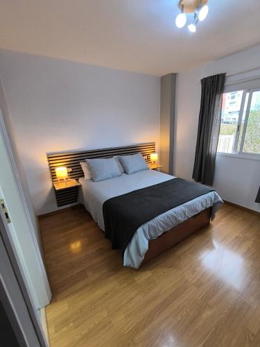 a bedroom with a large bed with two lamps at BRISAS DEL MAR Eddy,,AIR,WIFI in Candelaria