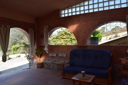 a living room with arched windows and a blue couch at Casa La Alegria in Maçanet de la Selva