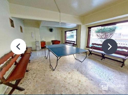 Una sala de estar con una mesa de ping pong. en Apto com 1 dormitorio proximo a praia, en Praia Grande