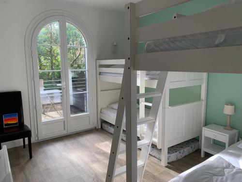 une chambre avec deux lits superposés et une fenêtre dans l'établissement Villa Les Conches 14 couchages avec piscine chauffée, à Longeville-sur-Mer
