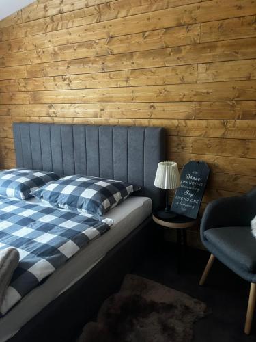 a bed with a blue and white checkered blanket and a lamp at Apartmán Oparno - České středohoří in Oparno