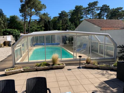 une maison en verre avec une piscine. dans l'établissement Villa Les Conches 14 couchages avec piscine chauffée, à Longeville-sur-Mer