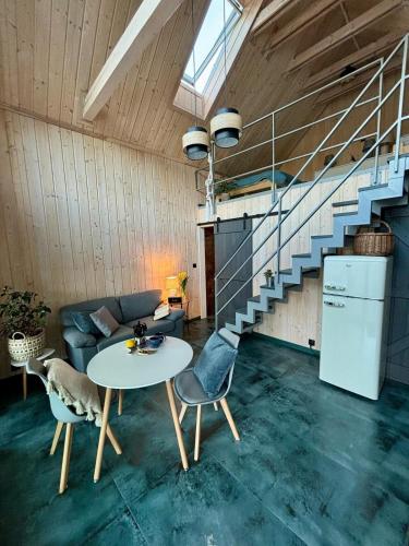 a living room with a table and a staircase at domek w stylu stodoły in Narty